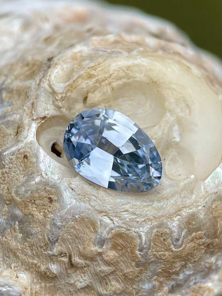 Close-up of a 1.74-carat Ceylon Sapphire in a custom Poval cut. Featuring a rich denim blue color, ethically sourced from Sri Lanka, untreated and natural.