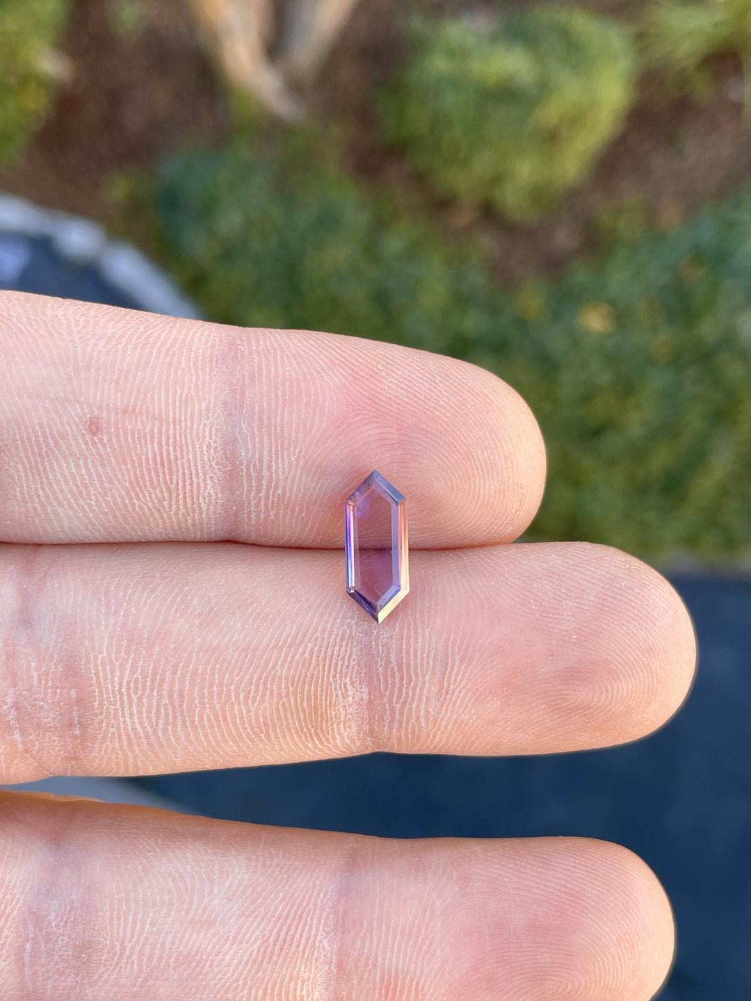 Close-up of a 1.81 carat spinel gemstone, featuring a hexagonal portrait step cut with vibrant purple and pink hues, untreated and sourced from Sri Lanka.