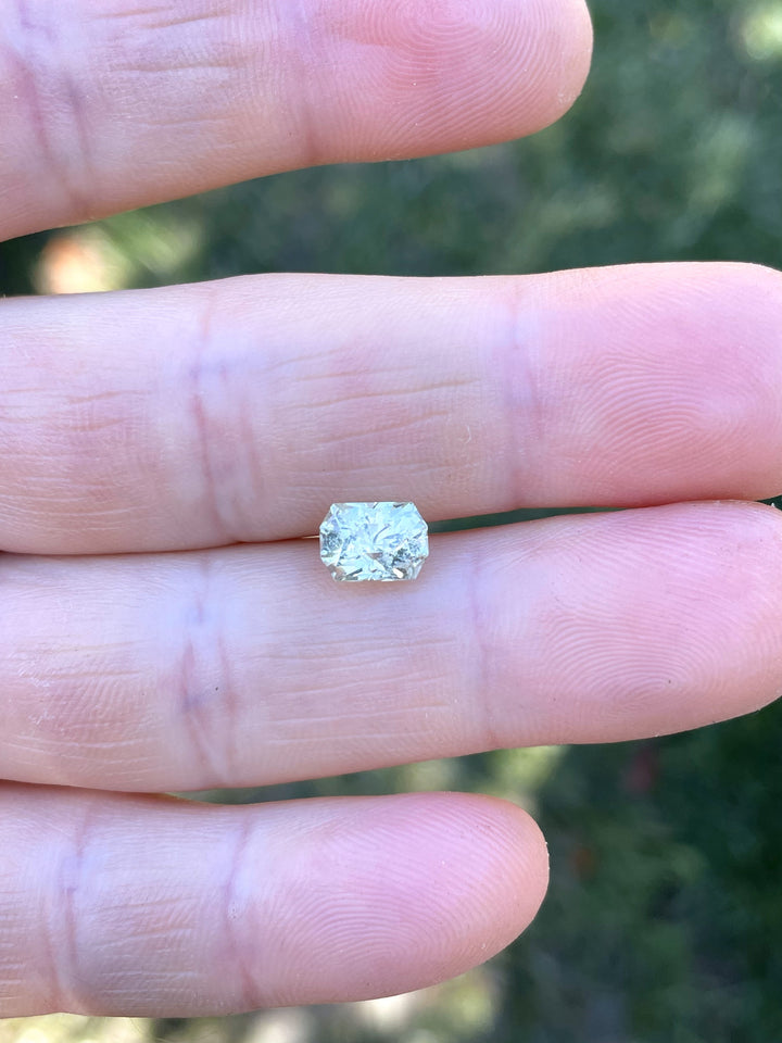 Hand holding a 2.04-carat yellow-green sapphire from Chimwadzulu Hill, Malawi, cut in Randy’s Cut Corner elongated octagon style.