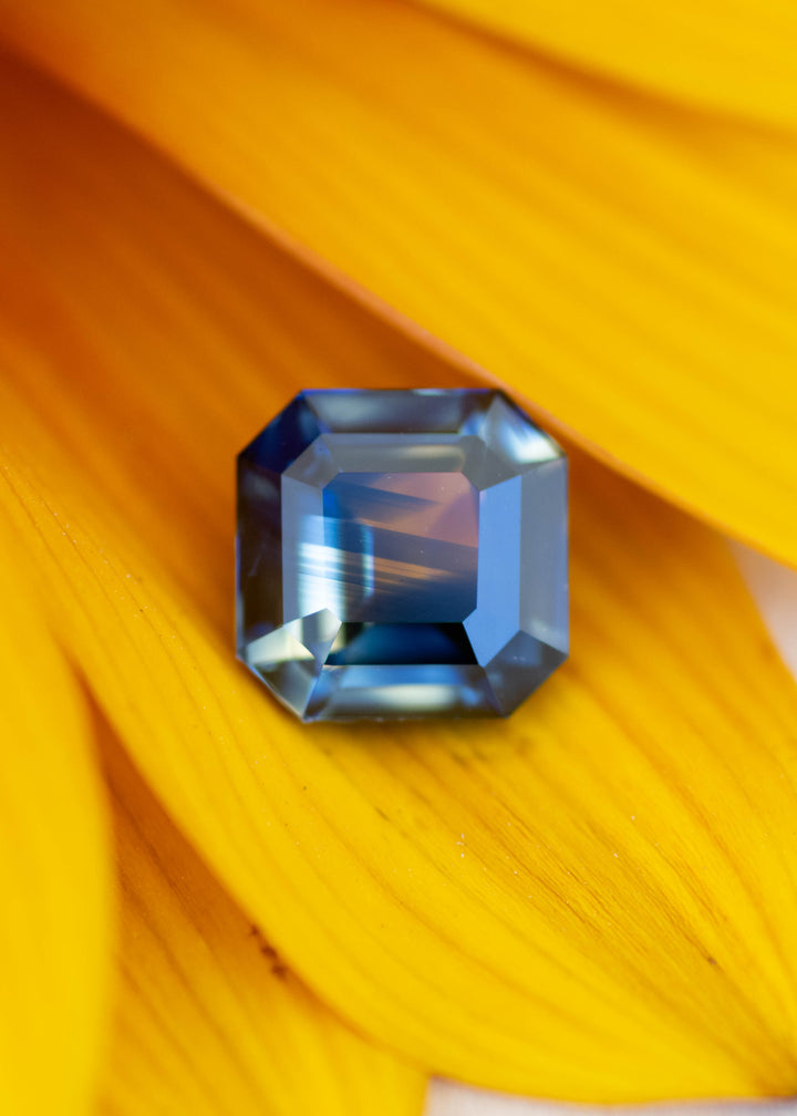 2.06 carat parti blue green yellow Asscher cut sapphire on yellow flower petals