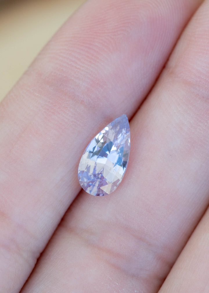 Loose 2.06 carat lavender pinkish purple sapphire shown on hand displaying a precision pear mixed cut from Madagascar.