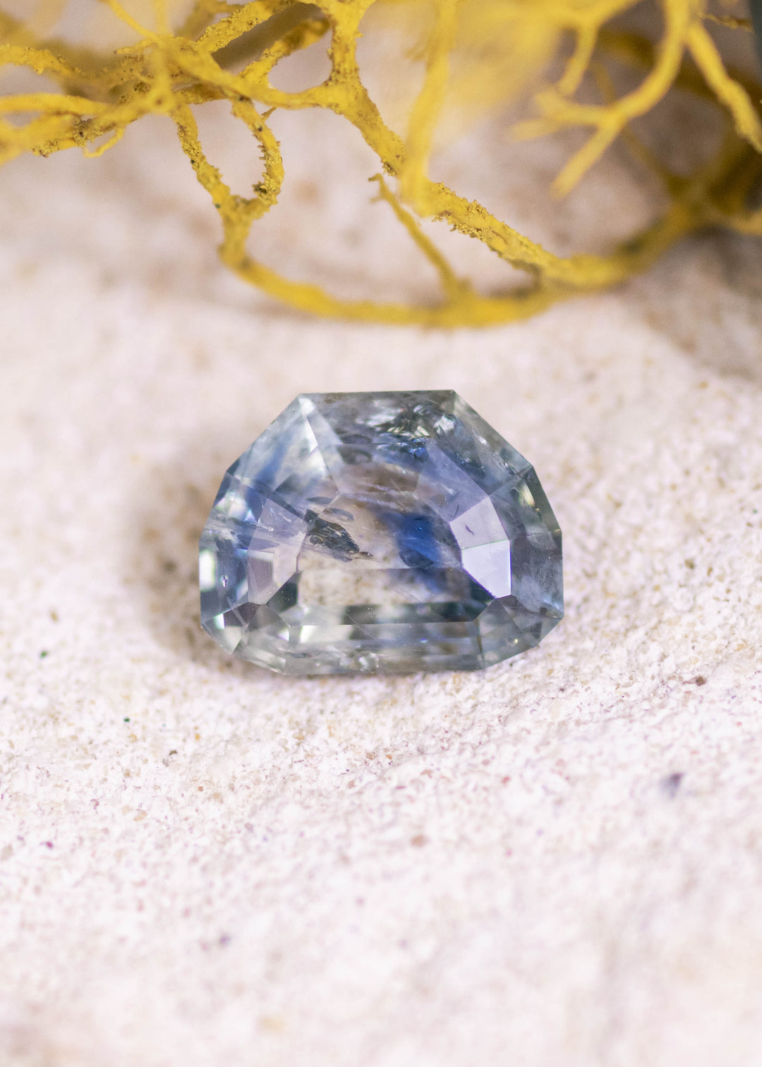 Loose 2.11 carat blue teal Montana sapphire shown face-up, highlighting the geometric tablet cut and layered step facets.