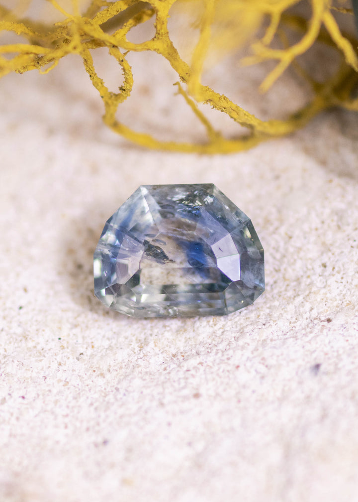 Loose 2.11 carat blue teal Montana sapphire shown face-up, highlighting the geometric tablet cut and layered step facets.