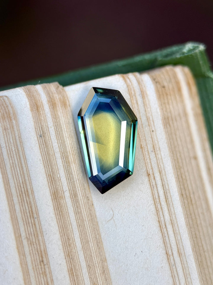 Faceted gemstone on a textured surface with a dark background