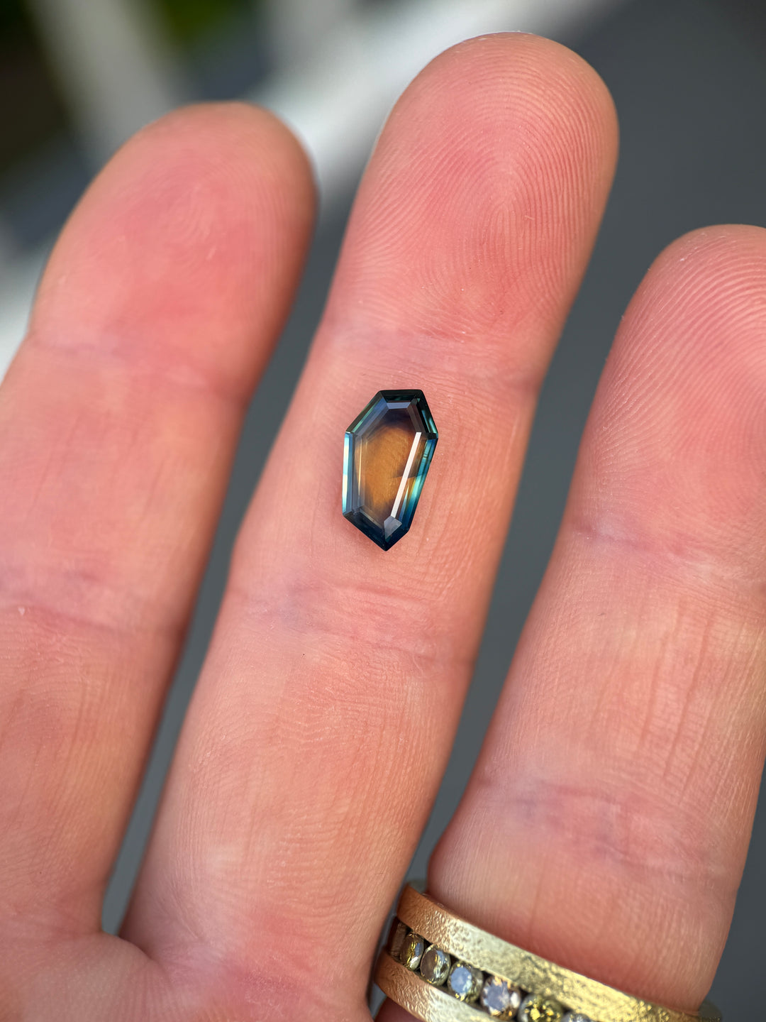 Small metallic hexagonal object held between fingers
