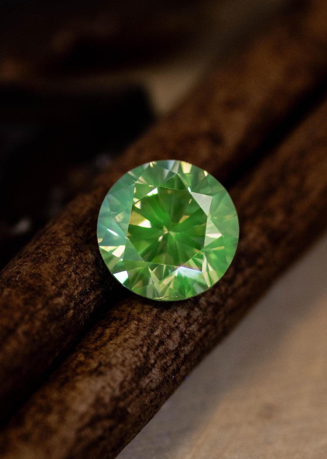 Loose fancy yellow brown diamond showing strong green fluorescence under lighting revealing unique glow effect.
