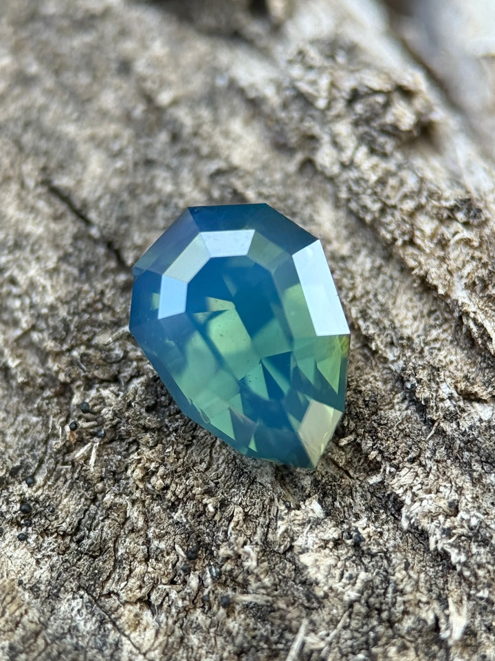 2.51 carat opalescent teal blue green sapphire shown face-up, displaying precision shield step cut faceting and luminous oceanic color from Diego, Madagascar.
