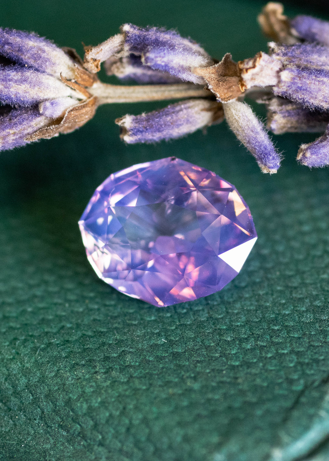 Loose 2.52 carat opalescent purple pink sapphire from Ratnapura shown face-up, displaying the precision oval mix cut and luminous pastel glow.