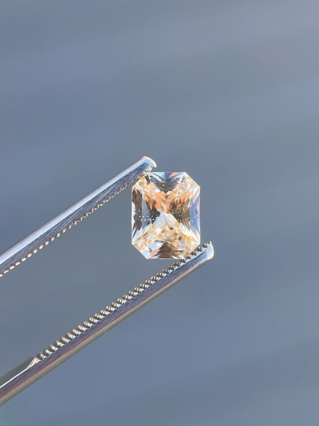 A natural 2.55-carat peach champagne sapphire with an octagonal mixed cut. Ethically sourced from Sri Lanka, this untreated gem displays soft peach and champagne hues with a sparkling brilliance.