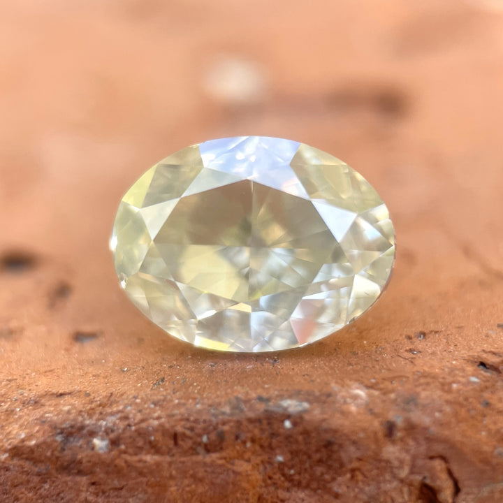 A stunning 2.71-carat faint yellow opalescent diamond, cut in an oval modified brilliant shape. This SI1 clarity diamond from South Africa showcases a unique interplay of light and color, making it a rare and beautiful gemstone.