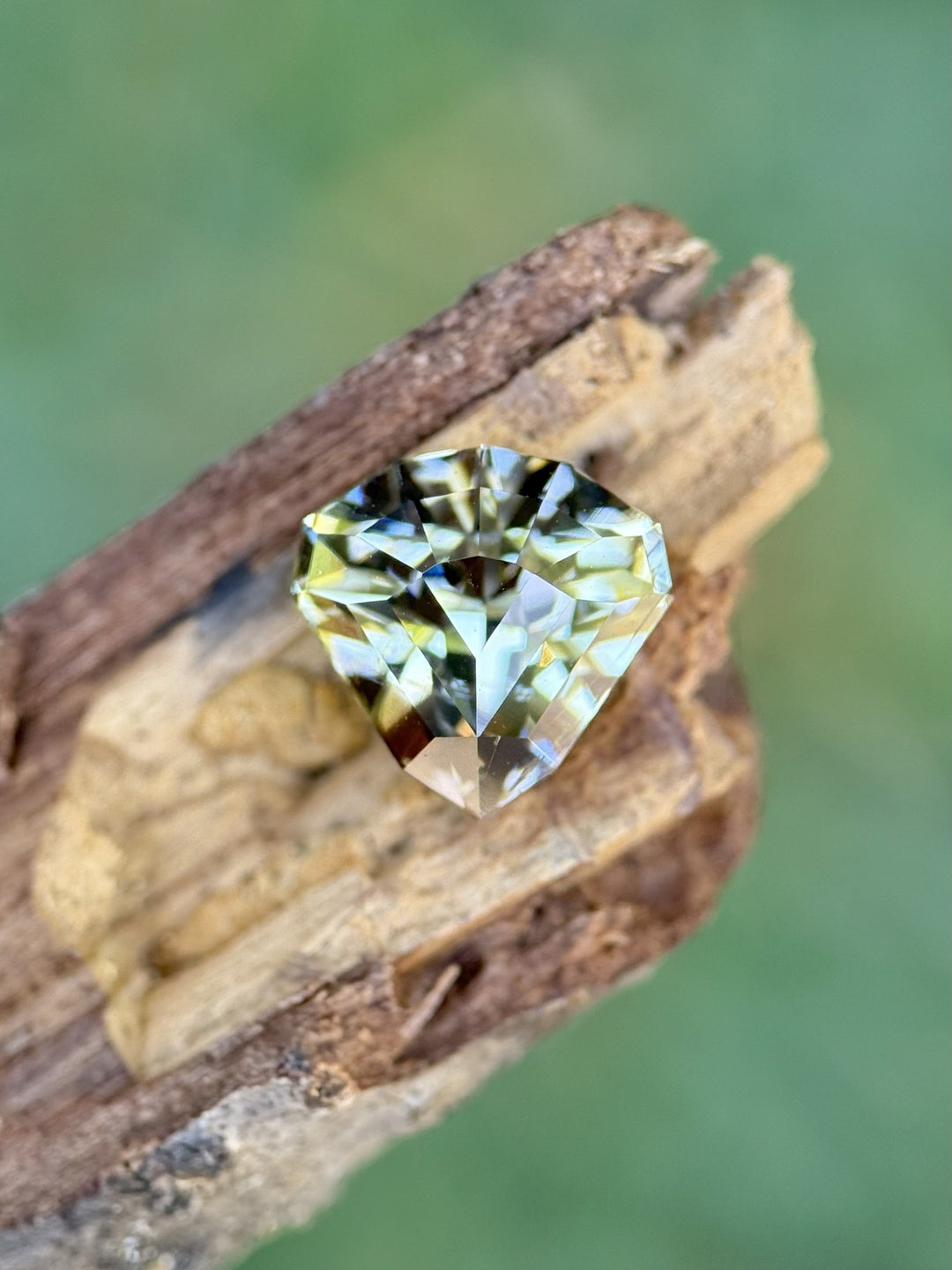 Ultra precision shield cut Tanzanite with mermaid hues resting on wood – 2.87ct ethically sourced from Merelani Hills, Tanzania