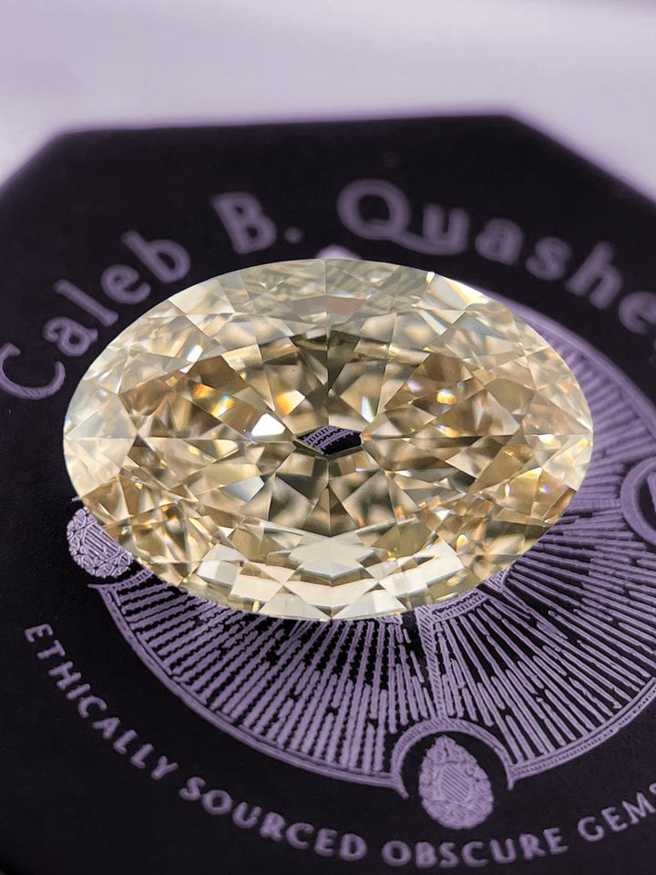 A stunning 3.01-carat fancy light brown champagne diamond with an antique-style old mine moval cut, displayed on a Caleb B. Quashen gem box, showcasing its flawless clarity and exquisite craftsmanship.
