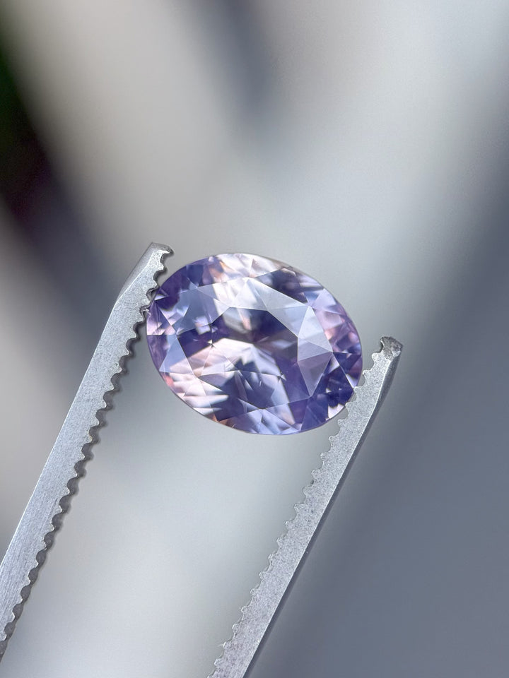Macro shot of 4.04 carat sapphire showing vibrant pink and violet reflections under studio lighting, precision custom oval cut from Sakaraha, Madagascar.