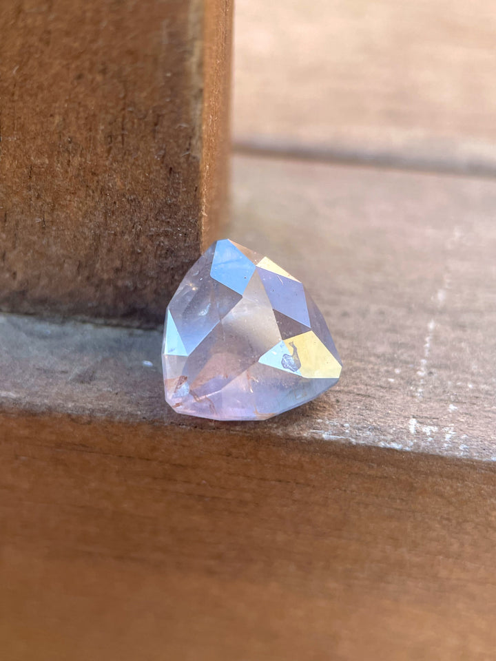 A unique 4.19-carat sapphire with a custom geometric trillion cut, exhibiting stunning gray, teal, and yellow hues. Ethically sourced from the Umba River, Tanzania, this untreated gemstone features a rare color-changing effect.