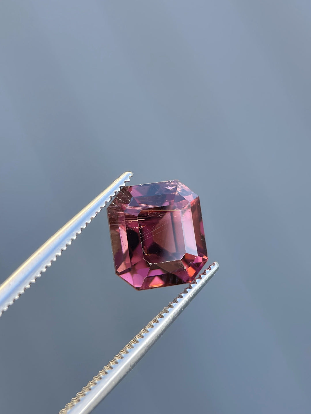 Exquisite emerald-cut tourmaline weighing 4.65 carats, showcasing a blend of red, purple, and pink tones, ethically sourced from Congo, Africa.