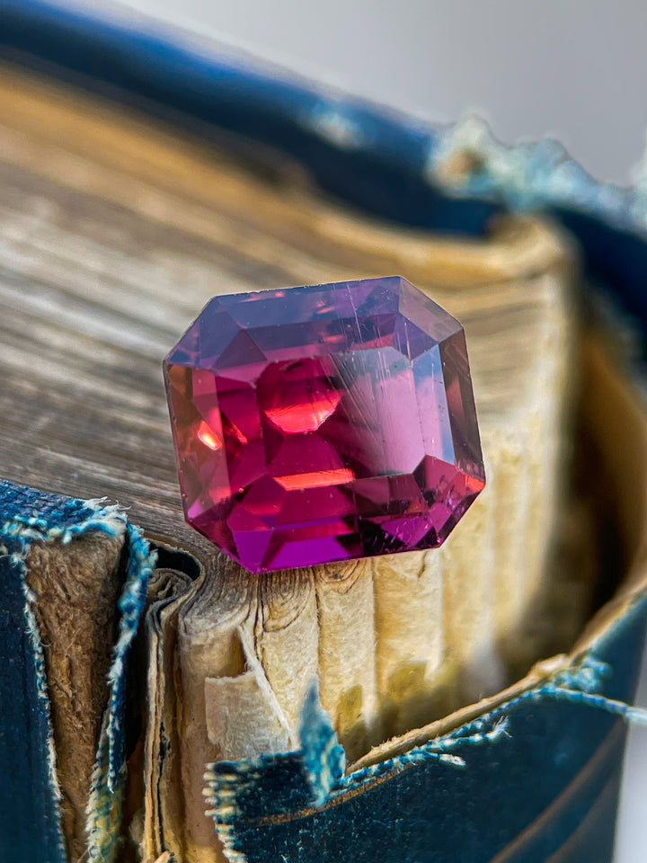 Stunning 4.65 carat emerald-cut tourmaline in vibrant red, purple, and pink hues, sourced from Congo, Africa, untreated.