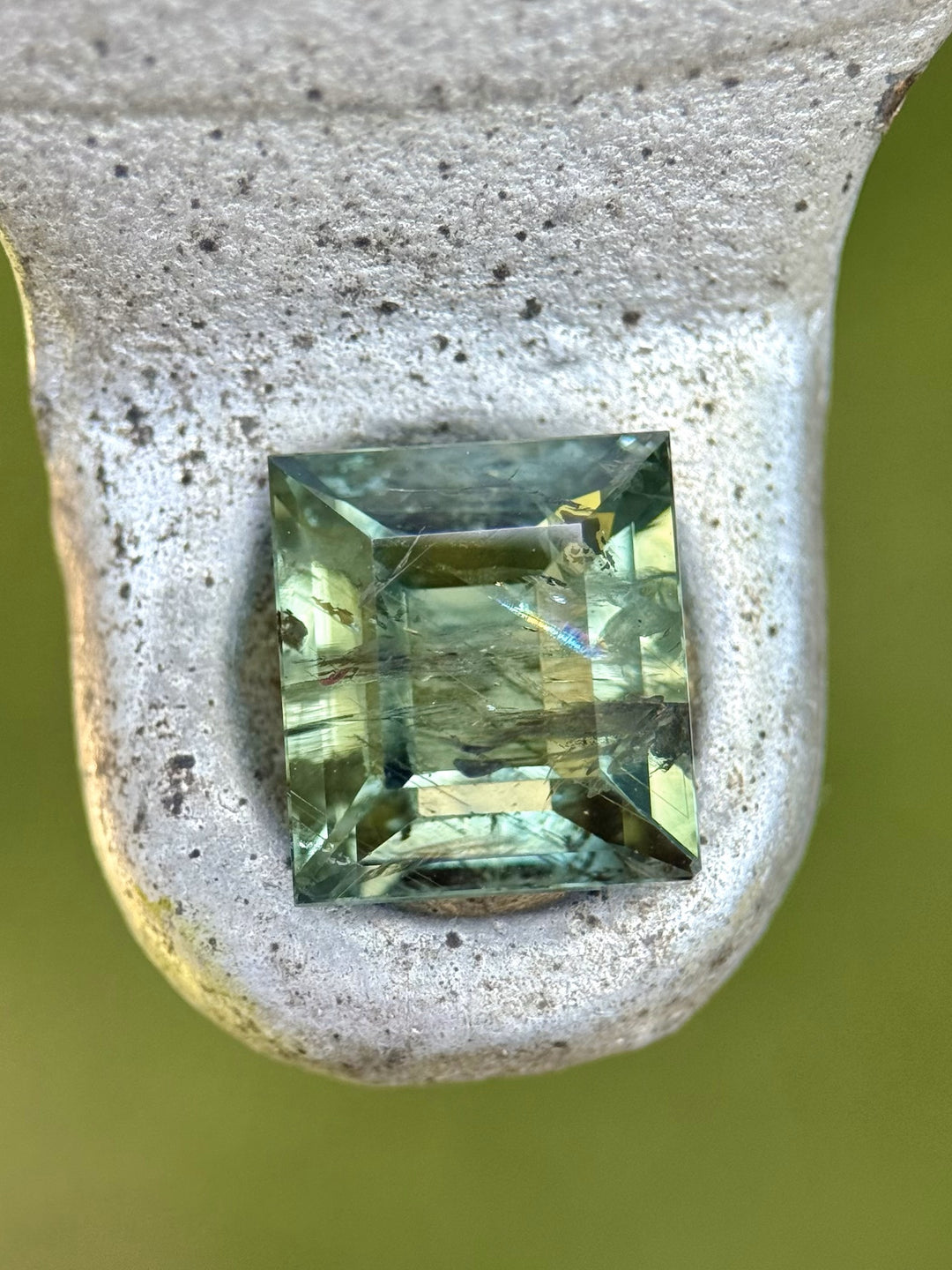 (On stone): Close-up of untreated Montana sapphire showing internal inclusions and color zoning