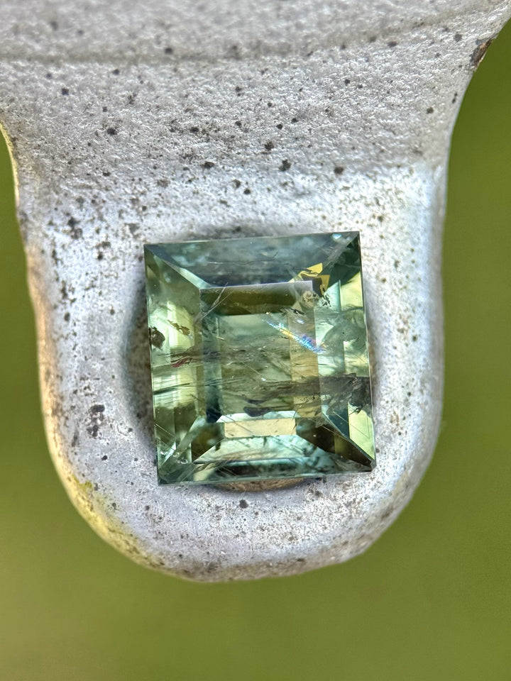 (On stone): Close-up of untreated Montana sapphire showing internal inclusions and color zoning
