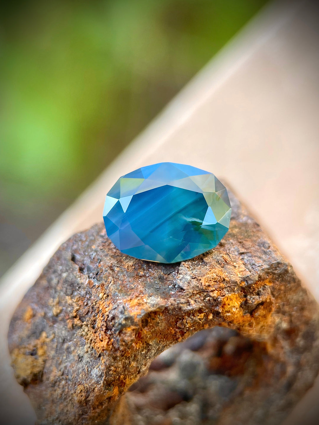 5.23 carat sapphire featuring blueberry, green, and teal hues, oval-shaped, dimensions 12.07 x 9.53 x 6.12 mm, untreated, originating from Gombe, Nigeria, valued at $6276.