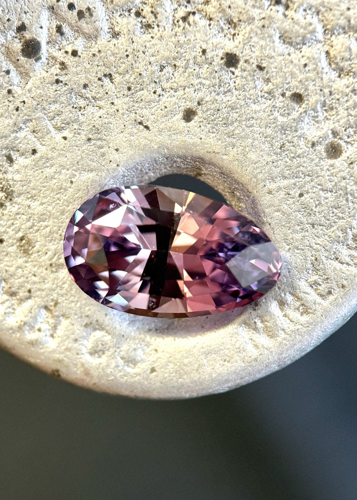 Loose 5.33 carat color changing sapphire from Sakaraha, Madagascar shown face-up, displaying purplish red tones in the modified brilliant pear cut.