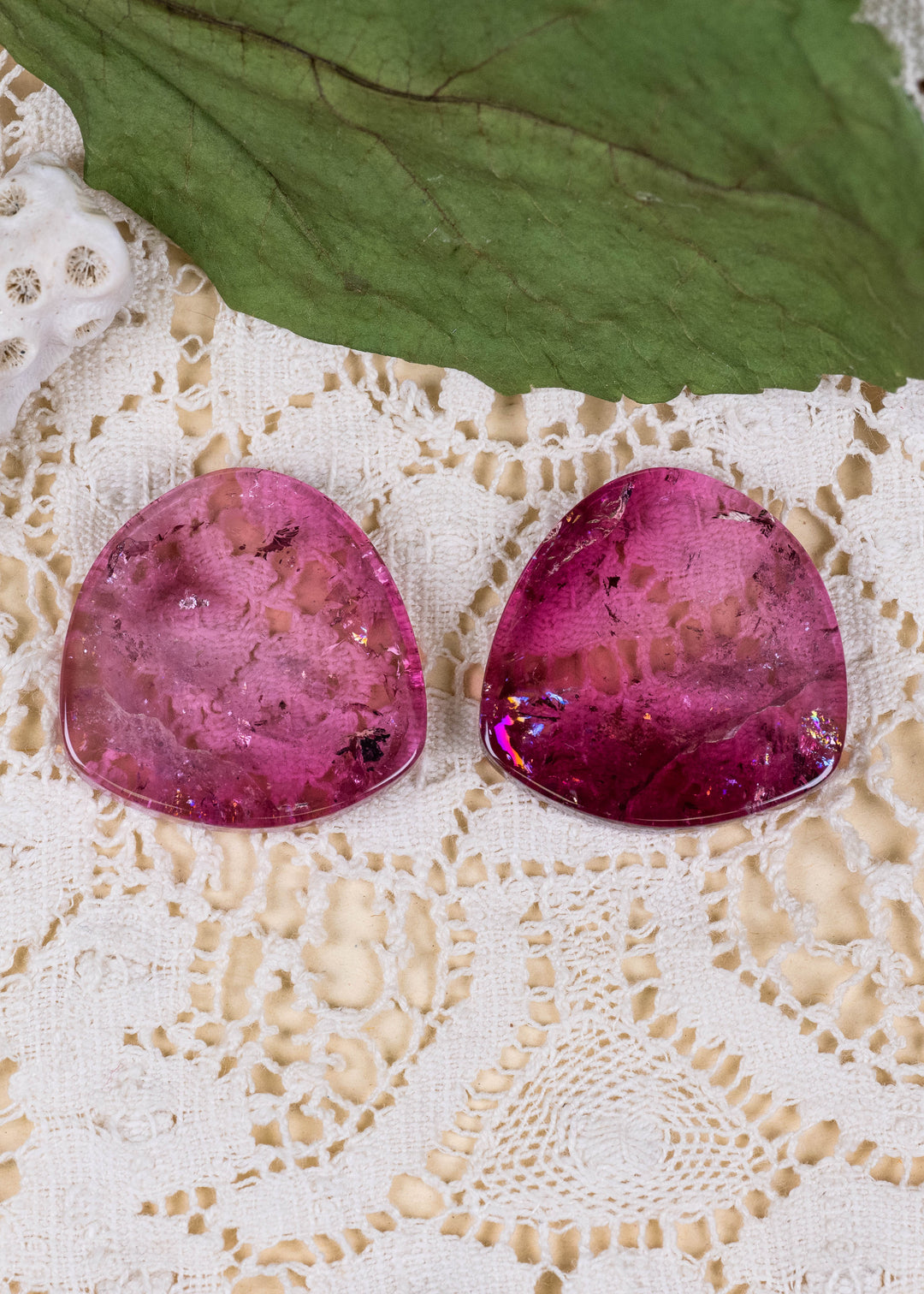 Explore a striking pair of natural deep pink tourmaline slices from Congo, totaling 65.78 carats. Each polished slice measures approximately 25.7 mm across, showcasing saturated raspberry and cranberry-pink coloration, translucent crystal, and distinctive natural inclusions. Their broad silhouettes offer an exceptional canvas for custom statement earrings, contemporary fine jewelry, and artistic gemstone designs.