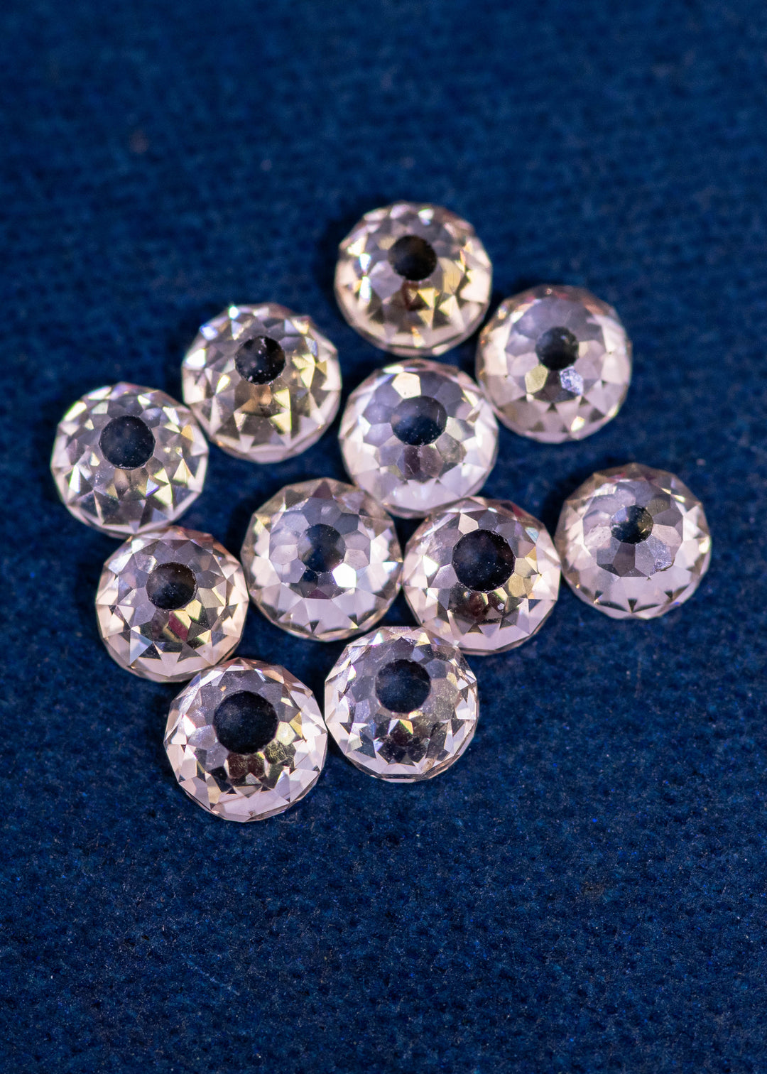 Parcel of 11 antique Mughal cut diamonds totaling 5.20 carats in fancy light brown color, arranged on deep blue fabric, showing hand-cut faceting, open culets, and untreated South African origin stones