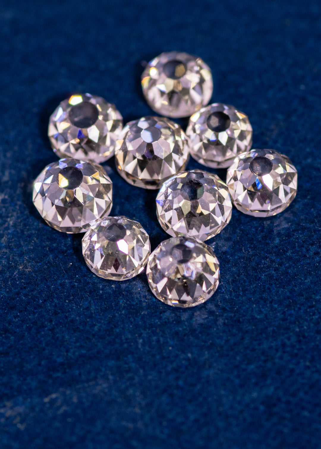 Nine Mughal cut diamonds arranged together on blue fabric, totaling 5.11 carats, fancy light brown color, VVS clarity, showcasing antique Mughal faceting from South Africa