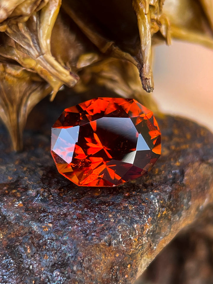 Hessonite Garnet gemstone, 1.68 carats, showcasing vibrant red-orange hues in a geometric brilliant oval cut, Kenyan origin.