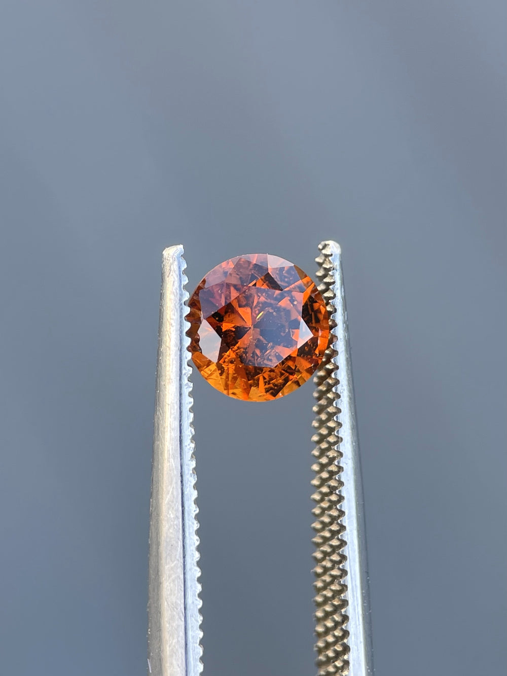 Kenyan Hessonite Garnet, 6.65mm diameter, showcasing its natural brilliance and untreated orange-brown hue.