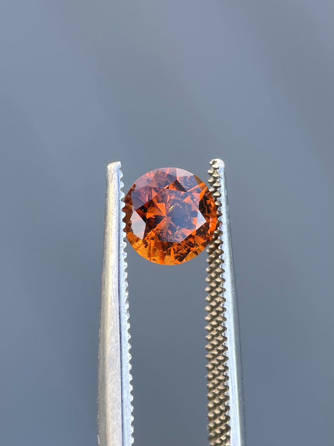 Kenyan Hessonite Garnet, 6.65mm diameter, showcasing its natural brilliance and untreated orange-brown hue.