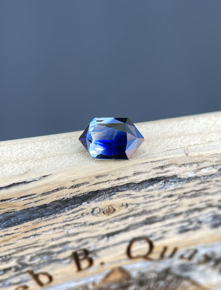 Close-up of 1.10-carat bi-color sapphire showcasing its hexagon cut and vivid royal blue and faint yellow tones.