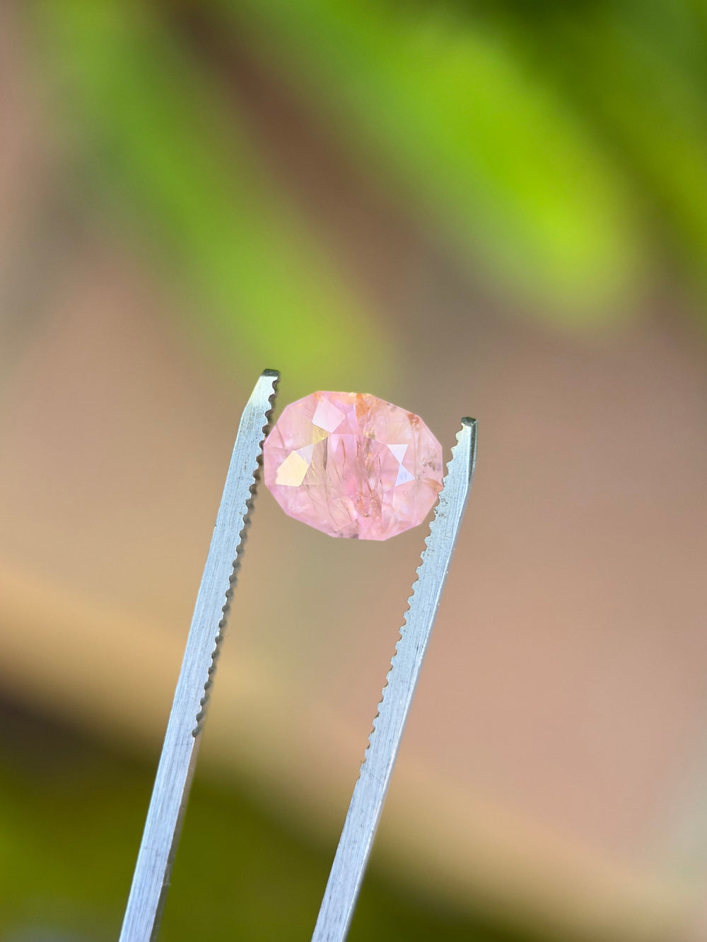 Close-up of a 4.08ct natural bubblegum pink Sri Lankan sapphire, showcasing its precision custom geometric oval brilliant cut and distinctive faceting.