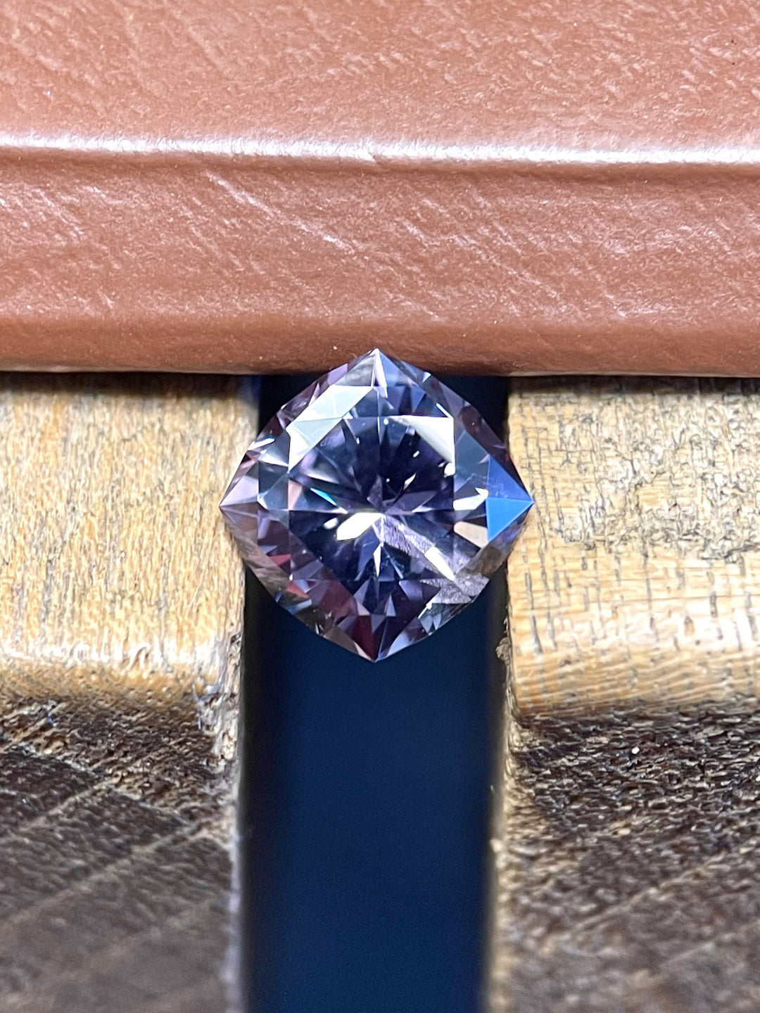 A composite image showcasing a 3.13-carat cushion brilliant sapphire's dual-toned beauty, transitioning between grayish green and pinkish purple, ethically mined from the El Dorado Bar Deposit, Montana, USA.