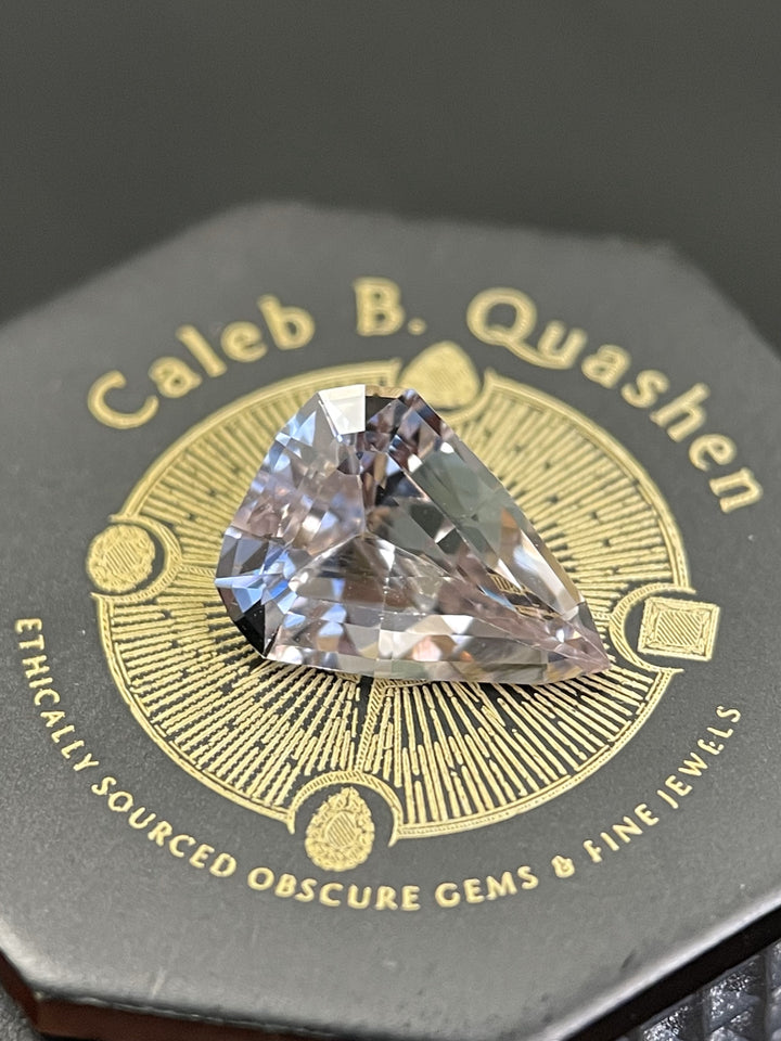 A stunning color-changing sapphire, shifting from pink to peach, featuring a modified geometric step cut design. The gemstone weighs 2.09 carats, measures 10.22 x 7.73 x 4.16 mm, and originates from Sri Lanka, untreated.