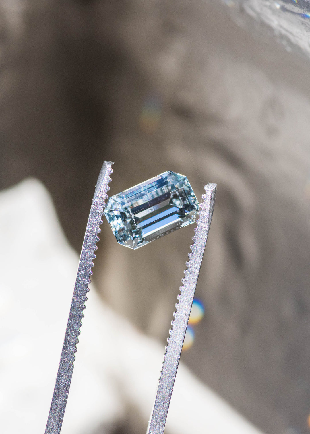 Close-up of a 1.63 carat untreated Colorado aquamarine showing its custom emerald cut, crisp step facets, and pale blue color.