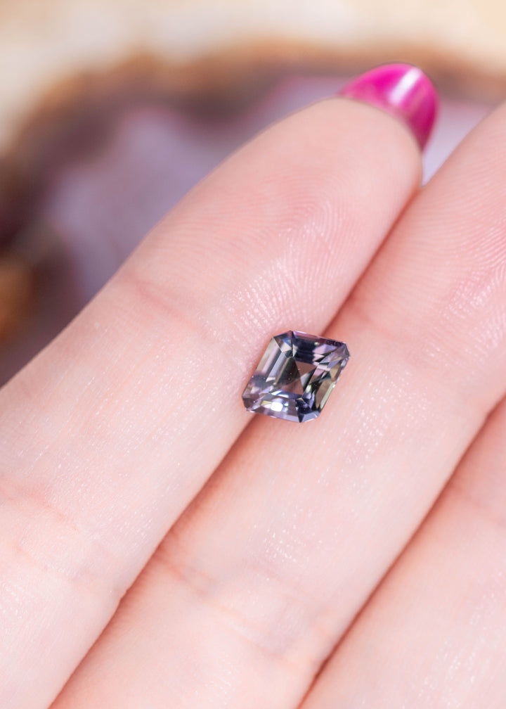 1.52 carat Tanzanite custom rhombus step cut resting on fingers showing teal blue green purple color shift and precision faceting from Tanzania