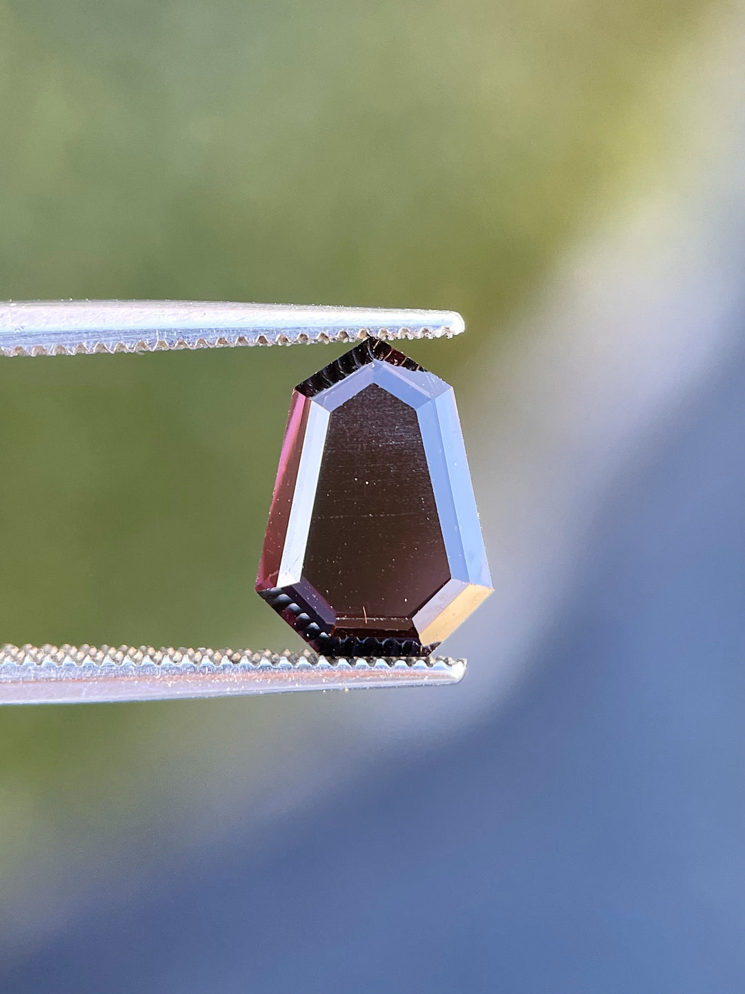 Detailed view of a natural spinel gemstone weighing 2.05 carats, featuring a shield step cut and vibrant red and purple tones, sourced from Sri Lanka.