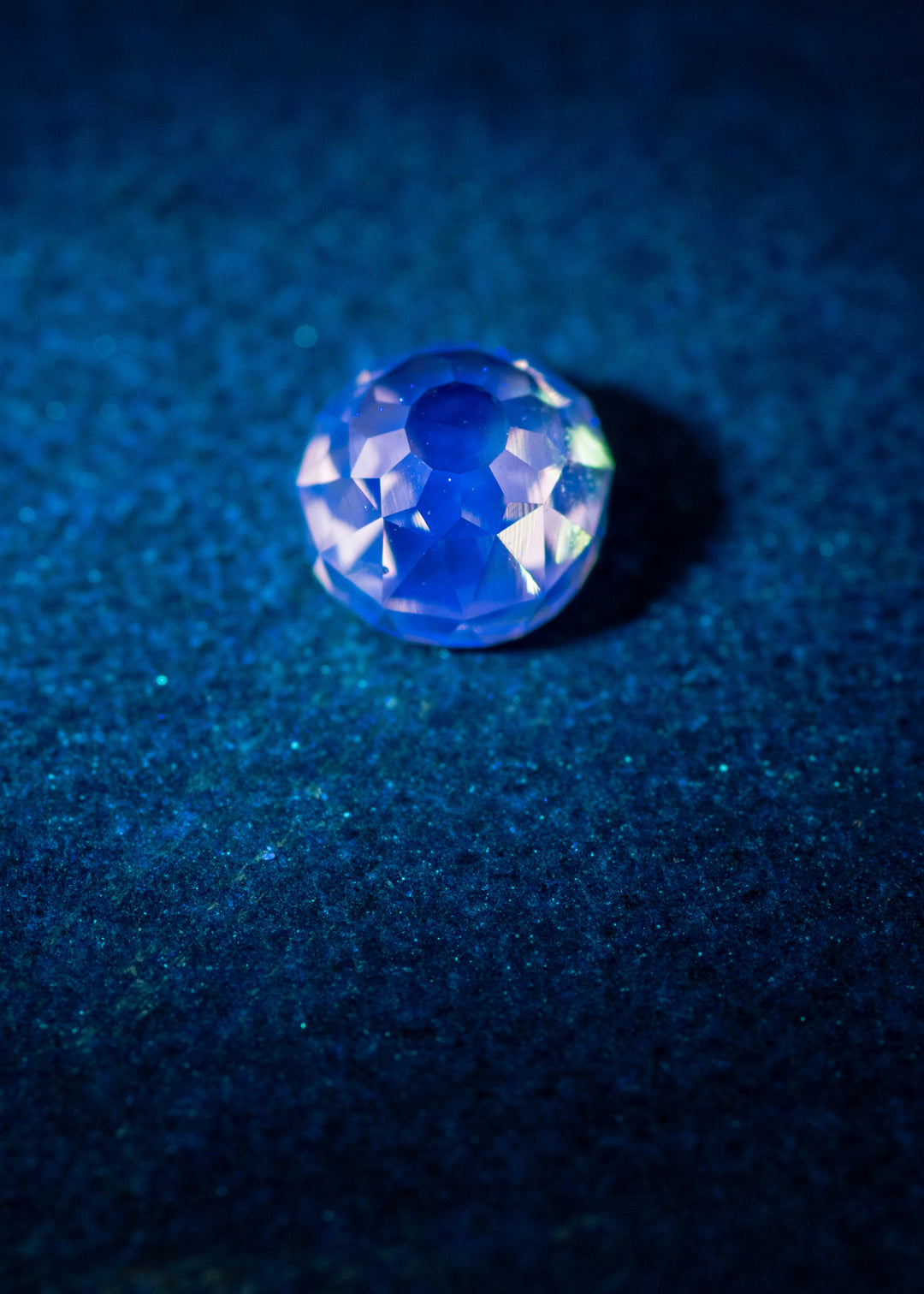 0.80 carat Mughal Cut Fancy Light Brown diamond glowing vivid blue under UV light, demonstrating very strong blue fluorescence and antique faceting from South Africa; untreated VVS2 clarity gemstone.