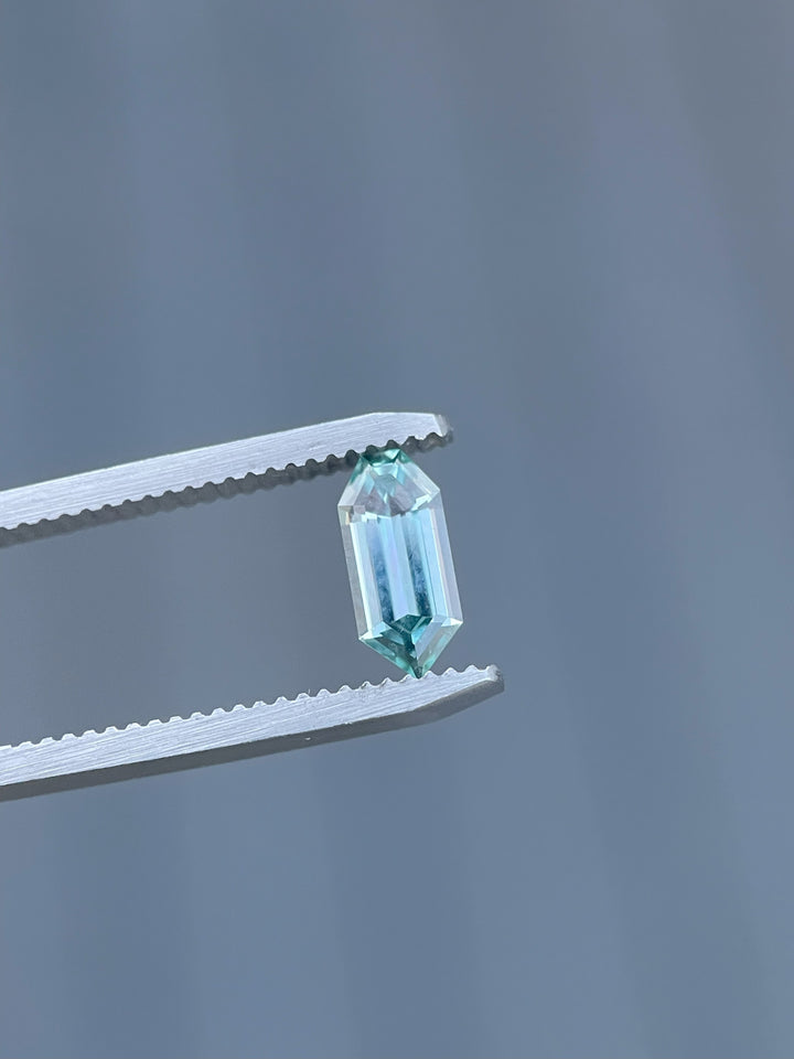 Hand-cut 1.05 carat sapphire from Montana, expertly crafted in a bullet-shaped septagon cut, sparkling with blue and teal hues.
