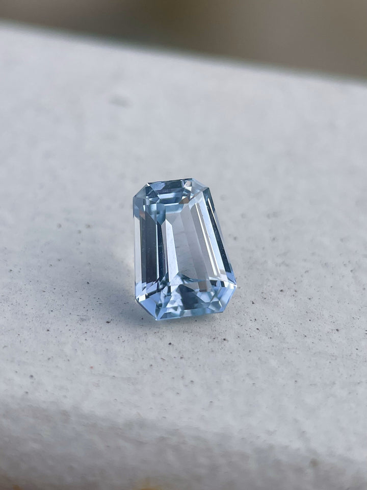 A close-up of a 1.64 carat pale blue sapphire in a fancy mixed cut, showcasing its pristine facets and soft blue color, sourced from Sri Lanka, set against a neutral background to emphasize its clarity and brilliance.