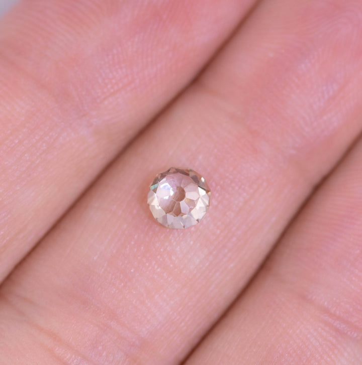 0.75 carat rosy champagne C4 fancy light brown diamond in Mughal cut displayed on fingertips for size reference, highlighting VVS2 clarity and natural color with strong blue fluorescence.