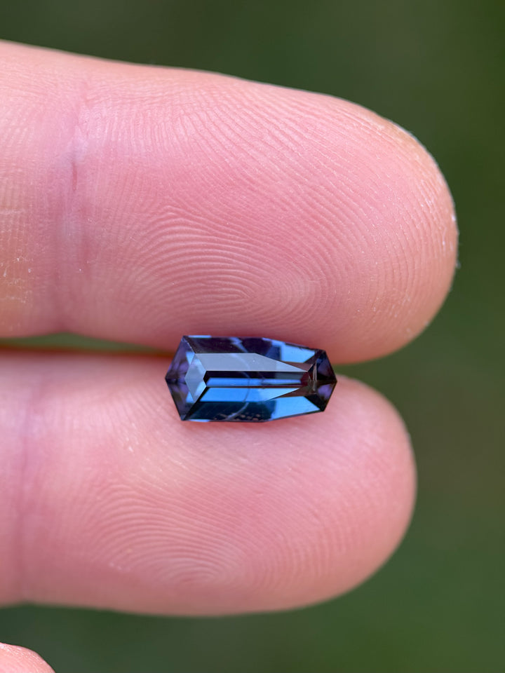 Handheld view of a 2.13ct unheated tanzanite in shield step cut with deep teal and violet hues from Arusha Region, Tanzania.
