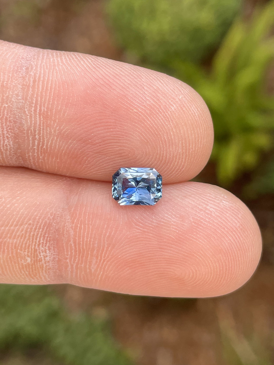 1.54 carat radiant-cut blue sapphire with shades of indigo and violet, sourced from Sri Lanka, showcasing a high-quality finish.