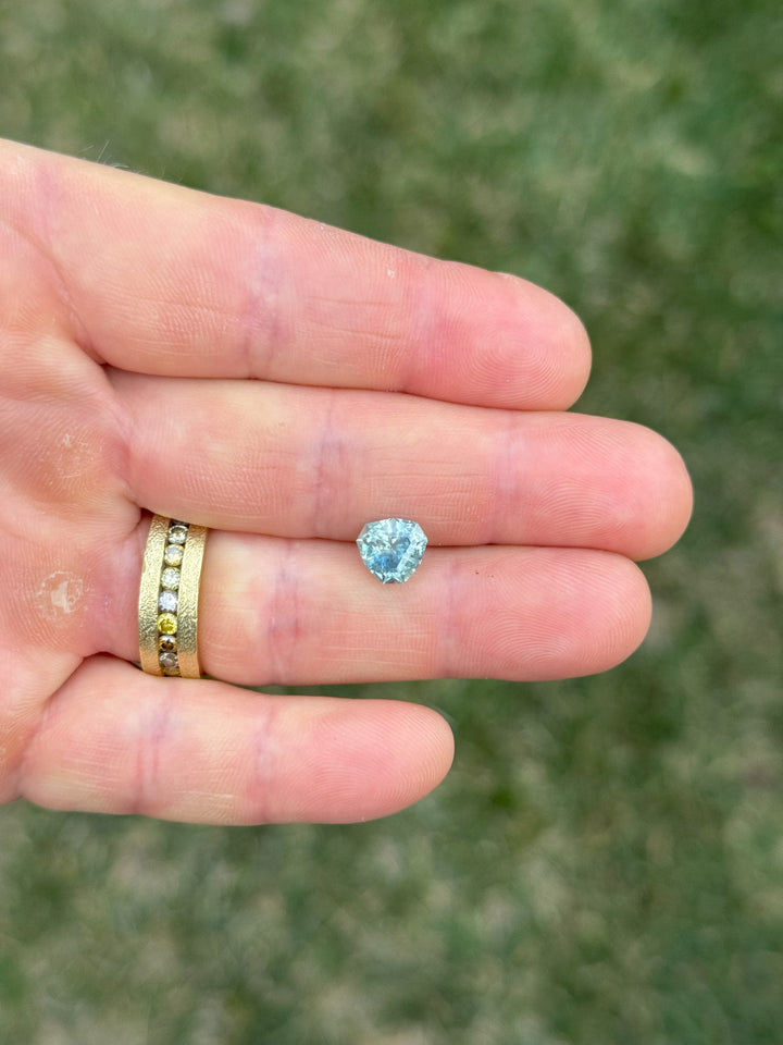 Hand-shot of 2.41-carat cut corner trillion parti sapphire from El Dorado Bar, Montana, showing denim and periwinkle hues.