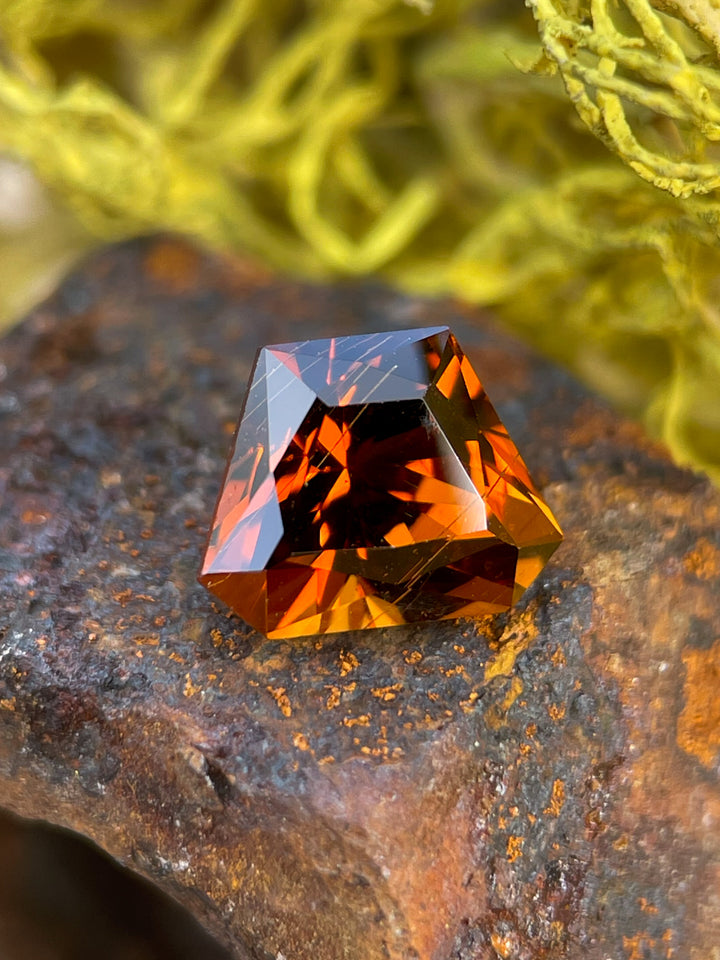 Hessonite Garnet with a Custom Geometric Shield Cut, showcasing a vibrant mix of yellow, orange, and brown hues, weighing 2.00 carats and sourced from Kenya.