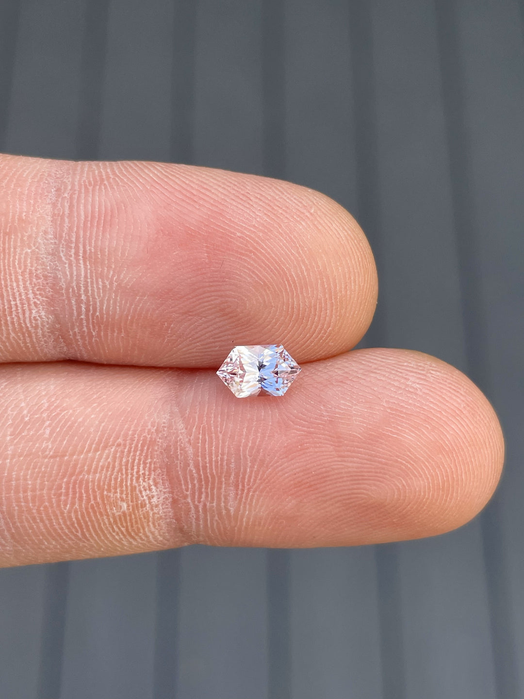 1.20 carat hexagonal mixed cut sapphire gemstone, showcasing vibrant peach and pink tones, untreated and originating from Sri Lanka.