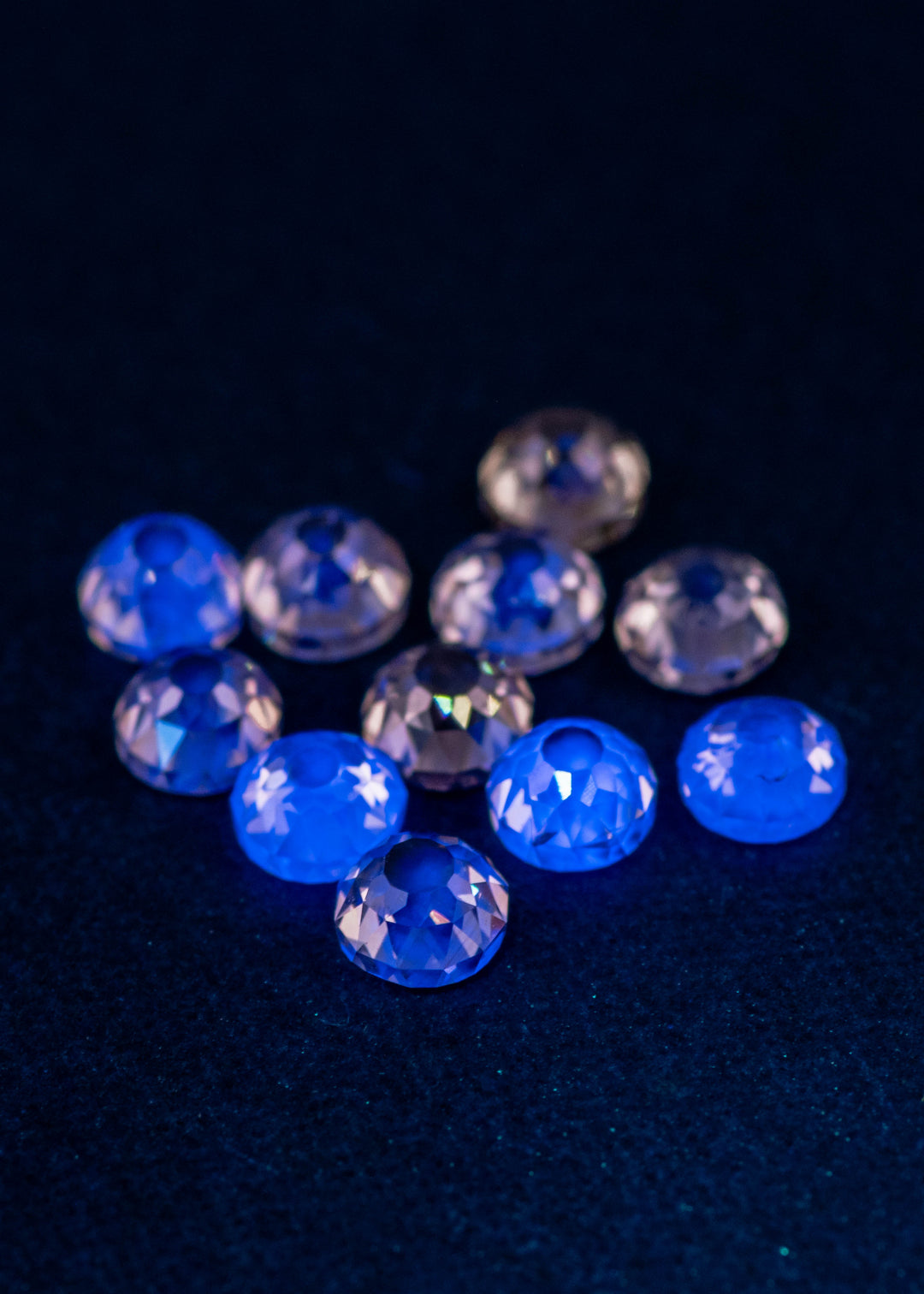Mughal cut fancy light brown diamonds glowing under UV light, displaying light blue fluorescence across an 11-stone 5.20 carat antique diamond parcel from South Africa