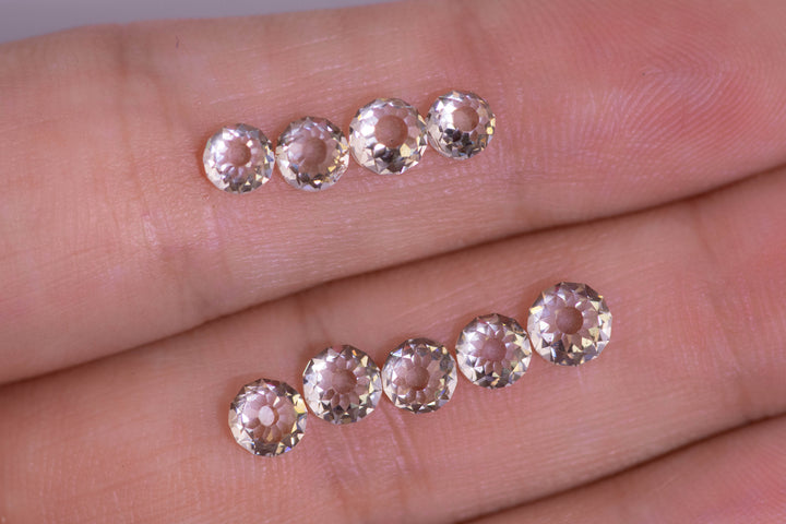 Five Mughal cut diamonds resting on a fingertip, showing scale and precision cutting, totaling part of a 5.11 carat fancy light brown diamond parcel with VVS clarity from South Africa