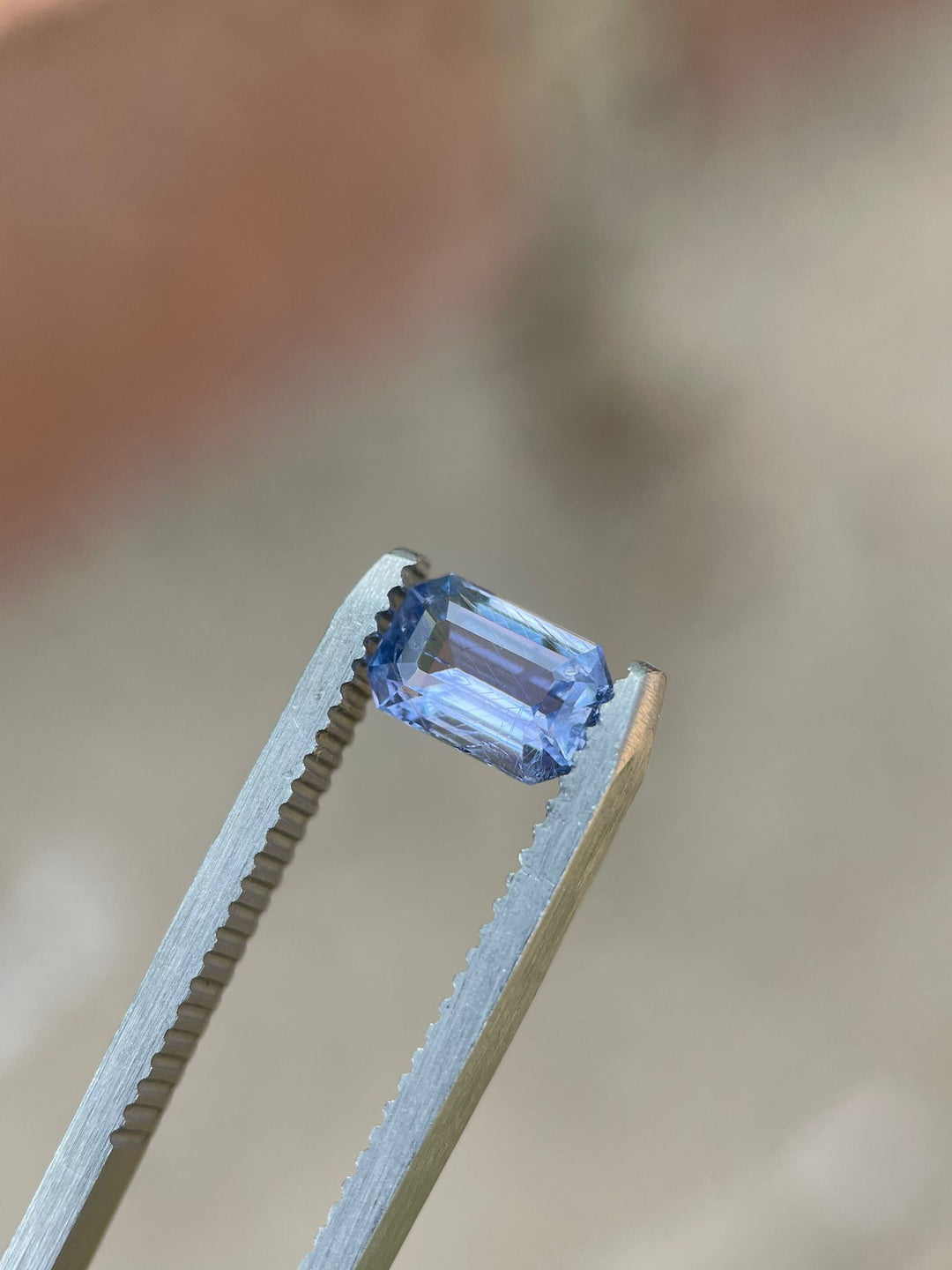 Violet-blue sapphire measured with calipers, focusing on the gem's precise dimensions of 7.50 x 4.97 x 3.21 mm, demonstrating its expert cut and quality