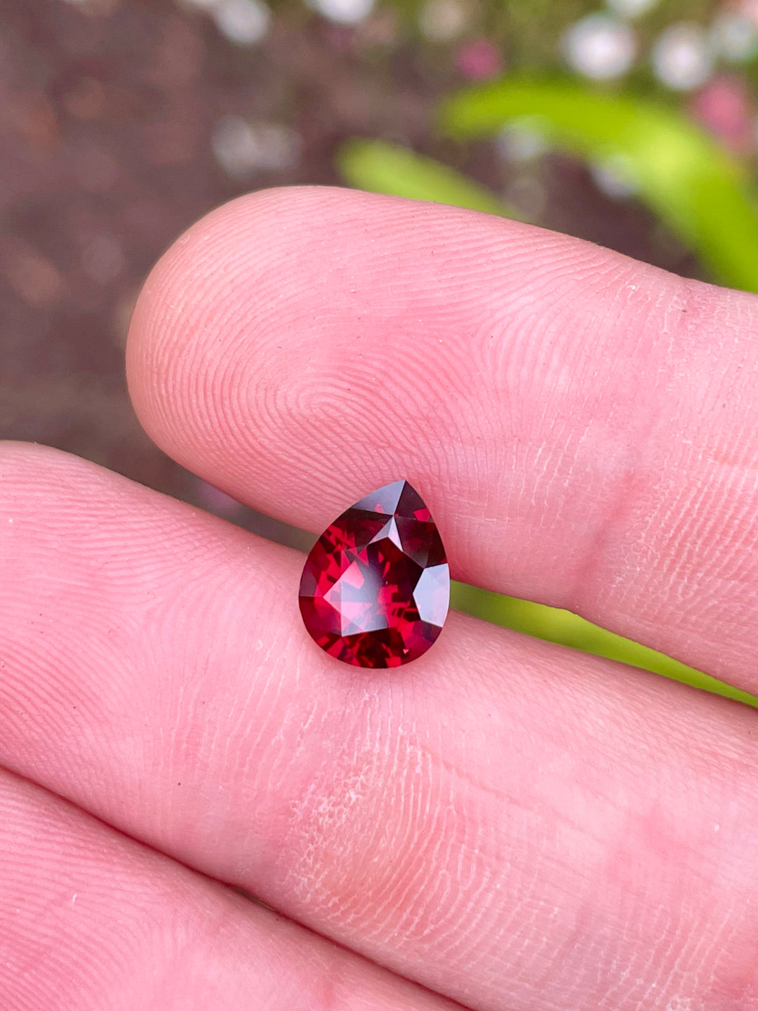 Exquisite 2.69 carat pear-shaped Garnet in vibrant shades of red, pink, and purple, measuring 9.95mm x 7.85mm, untreated and originating from Mombo, Tanzania, priced at $793.55.